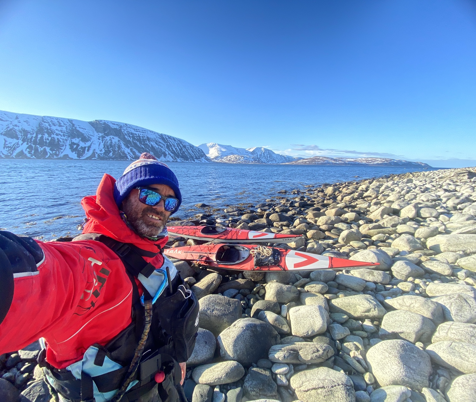 Julien Burellier avec ses kayaks sur une côte enneigée